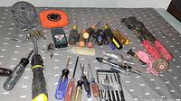 Overview of assorted hand tools including screwdrivers, Bosch laser level, Lufkin tape measure, pliers, pop rivet tool, and precision screwdriver set.