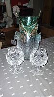 Two Irish crystal brandy glasses and one handblown crackle owl vase displayed on a table, showing size and relative positioning.