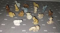 Top view of all 17 Wade Whimsies porcelain miniature animal figurines arranged on a dark surface.