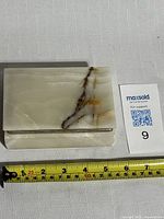 Top view of rectangular onyx trinket box showing natural brown and yellow veins and measuring tape indicating size around 6 inches wide.