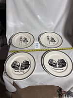 Four Royal Stafford dinner plates with skeleton bride and groom and skull Halloween designs, laid out with measuring tape showing approximately 10.75 inches diameter.