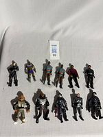 11 vintage Star Trek action figures laid on a white background, showing various characters from the 80s and 90s series with diverse costumes and alien features.