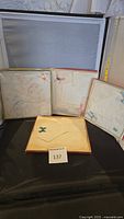 Four sets of linen handkerchiefs in original packaging displayed on black surface with label 137 visible.