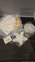 Photo showing starfish and shell resin molds and additional white molds in plastic packaging with a lot number card