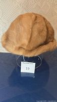 Front view of the small women's fur hat showing soft light brown fur material.