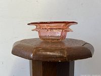 Ruffled edge coral pink art glass bowl, side profile showing shape and ruffle detail.