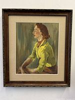Full view of framed Art Deco lady lithograph with beige mat and dark wooden frame.