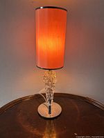 Front view of the lamp lit showing the warm glow and crystal details.