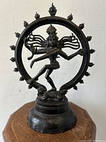 Front view of the bronze Shiva Nataraja statue showing the figure's detailed face, arms, and flame hoop surrounding.