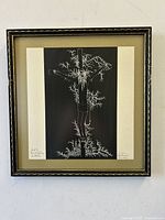 Full frontal framed artwork photograph revealing the lithograph centered in a beige mat and black and gold decorative frame on white wall.