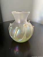 Side view of the iridescent art glass vase showing applied decorative teardrop elements and frosted, silky finish.