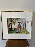 Front view of framed art print showing the full image, matting, and gold frame. Wall background visible.