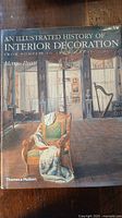 Front cover of 'An Illustrated History of Interior Decoration' book depicting a classical interior room.