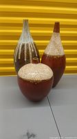 Three ceramic decorative vases, showing shape and glaze coloration including red, brown, and cream crackle glaze.