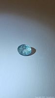 Photo of natural untreated Brazilian aquamarine oval cut gemstone on white background, 9.3 x 7.5 mm, 2.04 carats
