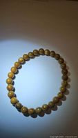 Natural jasper wood grain bead stretchy bracelet, round beads approx 6mm diameter, arranged in a circle on white background.