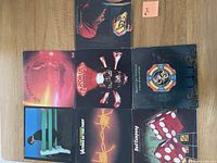 Photo showing seven vinyl album covers arranged on a wooden surface, including multiple albums by Electric Light Orchestra and others.
