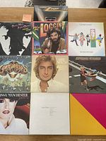 View of 9 of the 10 album covers, showing artist portraits and logos for Kenny Loggins, Starship, James Taylor, Jefferson Starship, Commodores, Melissa Manchester, and others.