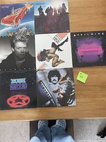 Seven vinyl album covers arranged in three rows with various Canadian artists. Includes Rush 2112 with a red star logo, Lighthouse Sunny Days showing band silhouettes, Bryan Adams Reckless with a close-up portrait, Frankie Goes to Hollywood Relax with a stylized image of a person in dynamic pose, April Wine First Glance with a dark cover and pink blurred image, Burton Cummings Dreams of a Child with a portrait of the artist, and Red Rider with band members in a red car illustration.