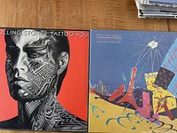 Front covers of two Rolling Stones vinyl records: 'Tattoo You' on left with black and white tattooed face profile on red background, 'Still Life (American Concert 1981)' on right with colorful abstract concert art.