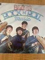 Front cover of 'The Beatles Rock n Roll Music' album showing all four band members with instruments and title text.