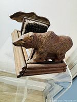 Side angle showing the detailed bear figure and brush cleaner wooden frame with brushes attached.