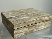 Perspective showing the rectangular jewelry box's bone and shell mosaic exterior and overall shape
