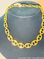 Full view of the yellow gold tone HOBE signed necklace displayed on a black bust, showing the design and length.
