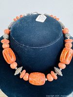 Front view of the carved bone and silver spacer choker necklace on a display bust showing bead details and overall style.