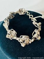 Full view of the sterling silver bracelet showing the connected floral and leaf motifs and the overall length and design.