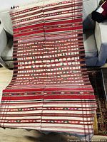 Full view of the rug spread over two sofas to display the design and size