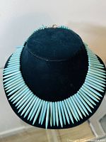 Front view of turquoise spike bead necklace displayed on black bust stand to show full length and arrangement