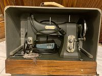 White Rotary Electric Sewing Machine Series 77 in original case, showing machine and power cord with plug wrapped on front.
