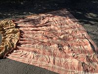Photo of entire curtain spread out on ground, showing pink striped pattern and heavy fabric.