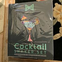 Front view of the box showing the Modern Mixology branding, colorful geometric cocktail glass design, and product name 'Cocktail Shaker Set' wrapped in clear plastic.