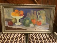 Full view of the framed still life painting on board depicting various fruits and bottles.