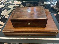 Both vintage wooden boxes stacked, showing wood grain, patina and wear including scratches and chip marks.