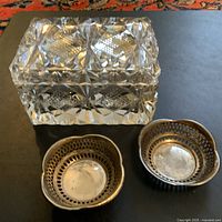 Overall view of the three vintage jewelry/trinket dishes: cut crystal box and two smaller metal dishes.