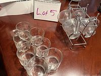 7 clear glass espresso cups arranged in two rows on a flat surface.