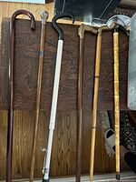 Photo showing all six vintage canes laid out side by side on wood surface.