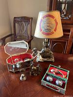 Camel lamp with shade and base detail next to musical jewelry box and small metal knick knacks on table