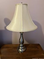Metal side table lamp with cream fabric bell-shaped shade