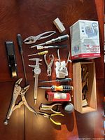 Overview of all tools including blood pressure monitor box, pliers, screwdrivers, stapler and wooden box