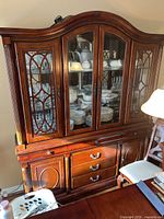 Full view of the solid wood china hutch showing the top glass doors with decorative wood mullions, drawers, and lower cabinets