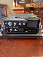 Front and top view of JVC 3050 Gemineye device showing screen, dials, controls, and carrying handle