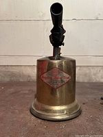 Front view of vintage Puji blow torch showing brass body and label.