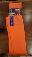 Orange Puma leggings folded with label showing size 10/12 and legging branding