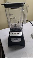 Full front view of Blendtec Classic 570 Black CTB2 Blender with clear WildSide+ container and black lid sitting on white surface.