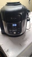 Front view of Ninja Foodi Air Fryer showing control panel and power cord.