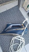 Side view of Rowenta Accessteam iron showing dark blue and silver casing, handle, label with 1725W printed